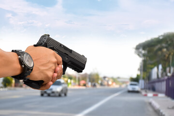 Automatic black 9mm pistol holding in hand, concept for security, bodyguard, safety, mafias,...