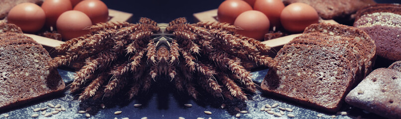 Fresh loaves of bread with wheat and gluten on a black table. Bakery and grocery concept. Fresh,...