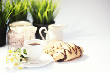 French breakfast on the table. Coffee croissant with chocolate and a decanter with cream. Fresh pastries and decaffeinated coffee.