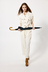 attractive woman in white suit umbrella in hands from rainy weather isolated background