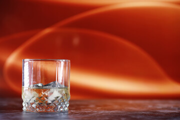 A glass of hard alcohol with ice on a bar counter. Whiskey with soda in a glass. Advertising alcoholic drink.