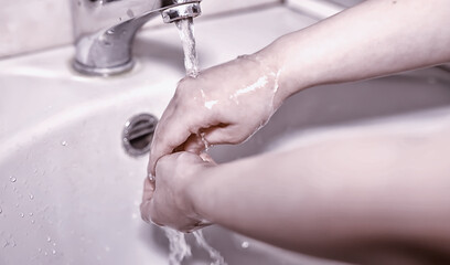 Fototapeta premium Hygiene rules. Hand washing before meals. Antibacterial treatment of hands with soap. A way to prevent virus infection. Coronavirus protection.