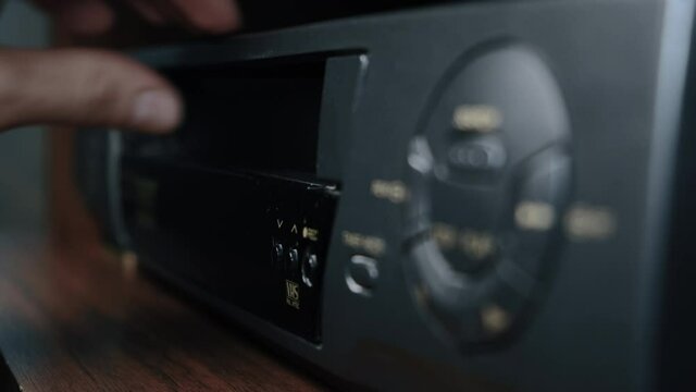 Hand insert a video cassette 