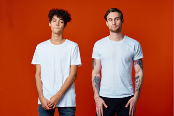 Two cheerful friends in white T-shirts are standing next to team emotions