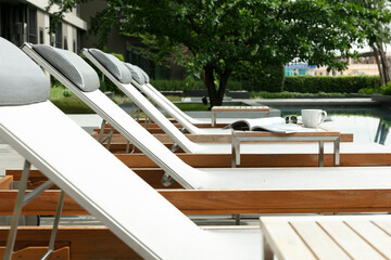 Chaise lounges on side of  swimming pool
