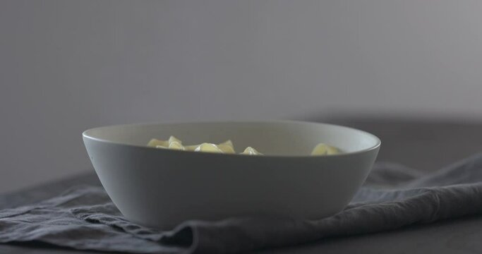 Slow motion put fettuccine into white bowl on linen cloth