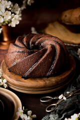 Homemade bundt cake with flowers on a dark background.