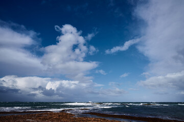 sunny day on the coast with storm clouds on the horizon