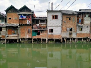 Fototapeta premium Roxy mas, Jakarta, Indonesia - (05-21-2021) : The slums in the capital, beside a river that is murky and dirty