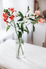 At the kitchen. alstroemeria, bouquet of flowers in glass vase on the wooden table