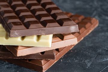 Various kind of chocolate on dark table.