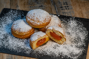 Freshly cooked Apricot jam doughnuts, referred to as jelly doughnuts, donuts in the US, The doughnuts have been fried, injected with a generous amount of jelly, jam and then dipped in caster sugar