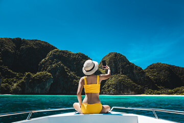 Traveler asian bikini woman with mobile phone travel on boat in Maya Bay Phuket Thailand - obrazy, fototapety, plakaty