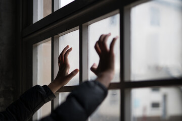 Woman with hands against the glass