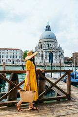 woman in yellow summer dress walking by Venice looking at grand canal © phpetrunina14
