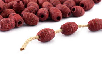 Wooden beads with natural jute string Twine Rope on white background. Close up, macro.