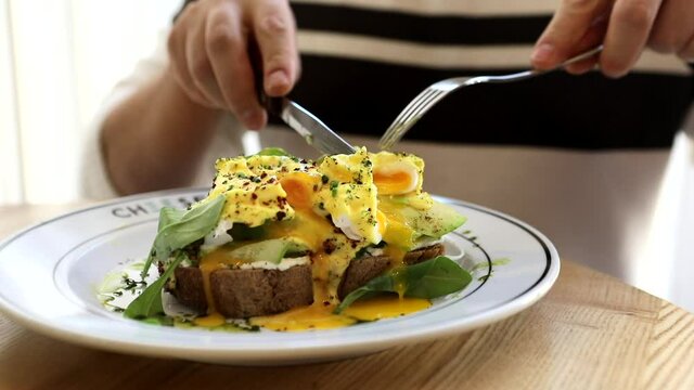 Man Eating At Cafe Sandwich Eggs Benedict Avocado