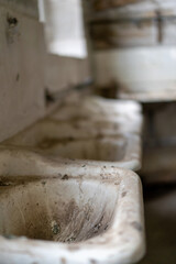 Fototapeta na wymiar old dirty and rusty sinks in disused warehouse 
