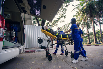In the epidemic crisis coronavirus (COVID-19), EMS team of paramedic react quick to provide medical help to injured patient accident at site work and transfer him in ambulance on a stretcher. © ME Image