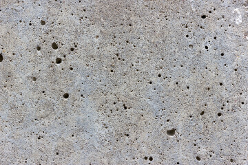 A flat grey concrete textured surface covered in air bubbles