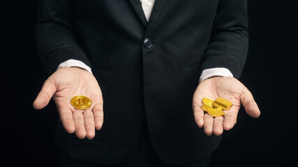 Businessman compare between cryptocurrency bitcoin coin with gold bar on hand. Cryptocurrency...
