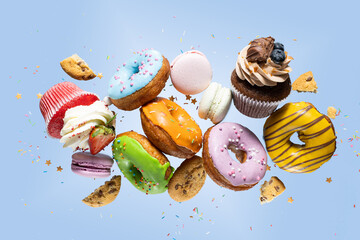 Colorful decorated donuts falling in motion on pink background with sprinkling. Sweet and various...