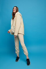 Young hipster fashion woman wears beige hoodie, pants and vest.