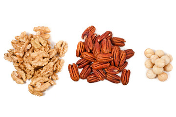 Heaps of peeled pecan nuts, walnuts and macadamia isolated on white background. Top view.