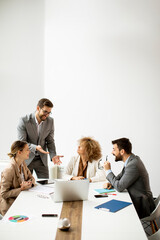 Group of young business people working and communicating while sitting at the office desk together
