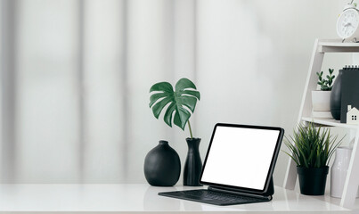 portable office desk with mockup computer devices, supplies and decorations on white table.