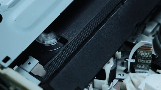 A cassette tape is inserted into the VCR, and the video from inside is played. Close-up