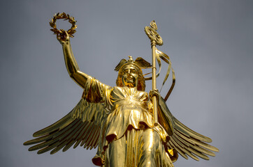 Fototapeta premium Siegessaule or Victory column with golden statue in Berlin, Germany. Time lapse of clouds passing behind monument. Major tourist spot and sight in city. Famous landmark and popular tourist attraction.
