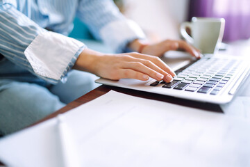 Close up picture of females hands on the keyboard. Young female freelancer working at home using her laptop. Distant work and education online. Working from home in quarantine lockdown.