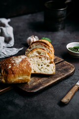 Homemade Ciabatta Bread. Sliced ​​bread slices on a wooden board. Bread with pesto sauce