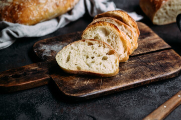 Homemade Ciabatta Bread. Sliced ​​bread slices on a wooden board. Bread with pesto sauce