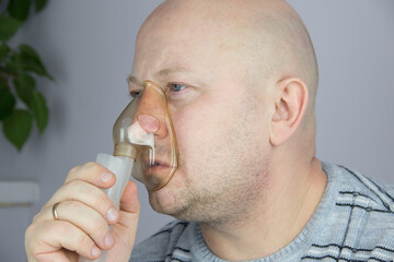 Man Doing Inhalation Through Oxygen Mask At Home