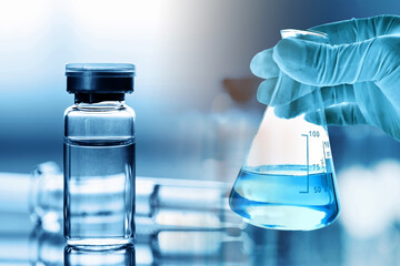 Hand of doctor holding flask, coronavirus vaccine bottle development vial dose flu shot drug, medical concept vaccination hypodermic injection treatment disease care hospital illness disease.