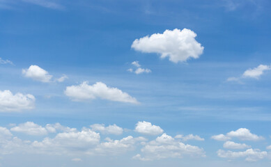 Naklejka na ściany i meble Beautiful white fluffy clouds on vivid blue sky in day light