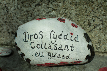 Red poppy wreaths laid at the bottom of a war memorial for Remembrance day