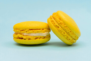 two yellow macaron cakes on a blue paper background