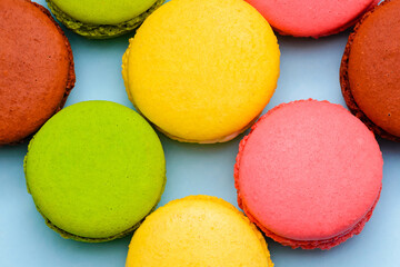a lot of color macaron cakes on a blue background