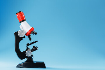 Microscope for laboratory medical research and experiments on a blue background.
