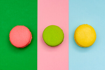 three color macaron cakes on a three paper color background