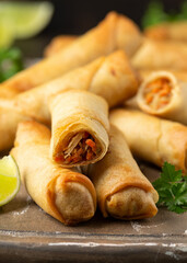 Fried vegetable spring rolls with sweet chili and soya sauce on wooden board