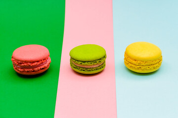three color macaron cakes on a three paper color background