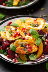 Fried Halloumi Cheese salad with beetroot, orange, pomegranate and pumpkin seeds, red onion, green vegetables. healthy food