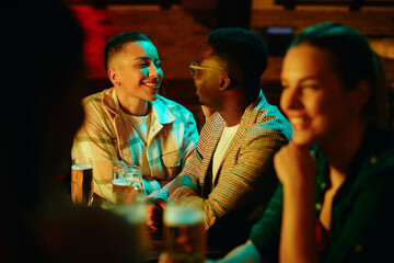 Happy African American couple talking during a night date at the bar.