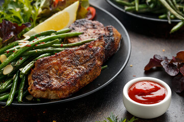 Grilled pork loin chops served with French green beans salad and beer