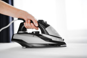 woman ironing a white sheet on a blackboard on a light background. wife's household chores