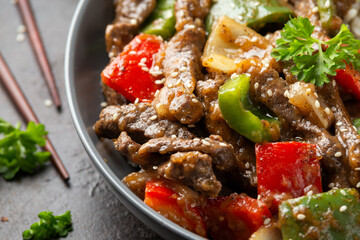 Stir fry Chinese pepper beef steak with onion, red and green bell pepper, rice in bowl